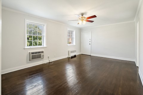 a living room with wood floors and a ceiling fan