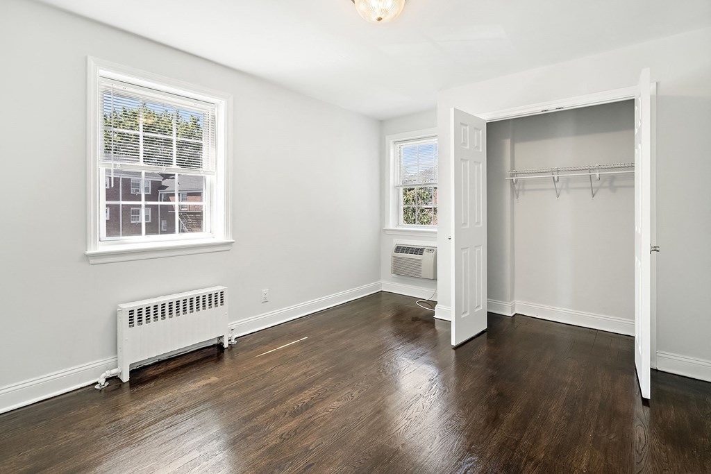 an empty room with wood floors and white walls and a closet