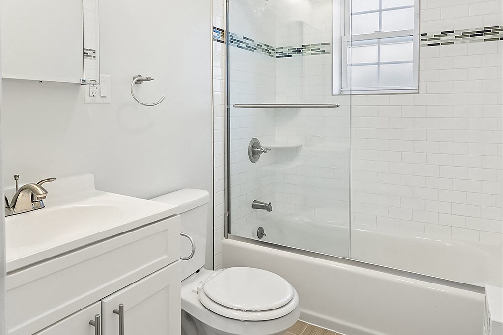 a white bathroom with a shower and a sink and a toilet