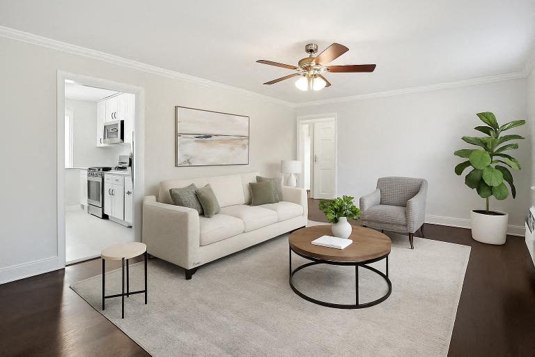 A living room with a white couch, a coffee table, and a ceiling fan.