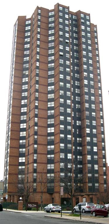 a tall building with cars parked in front of it