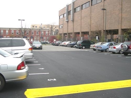 a parking lot filled with cars in front of a building