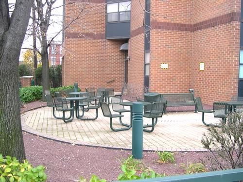 a group of tables and chairs outside of a brick building