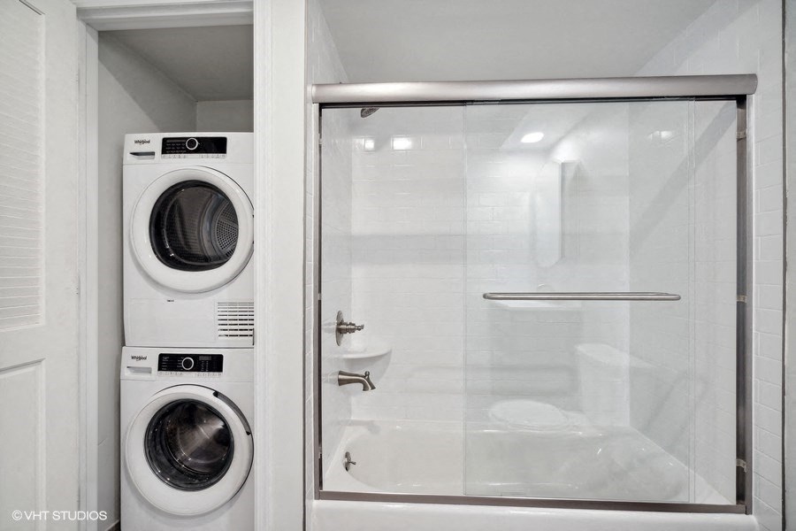 a bathroom with a washing machine and a glass door