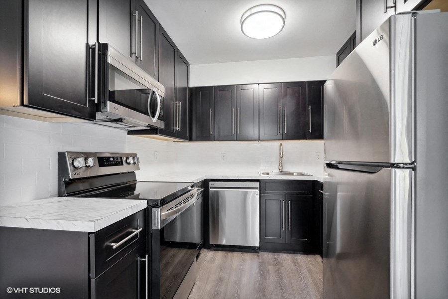 a kitchen with stainless steel appliances and black cabinets