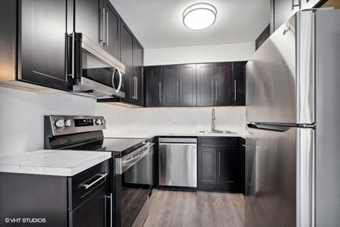 a kitchen with stainless steel appliances and black cabinets