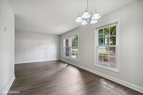 an empty living room with white walls and a window