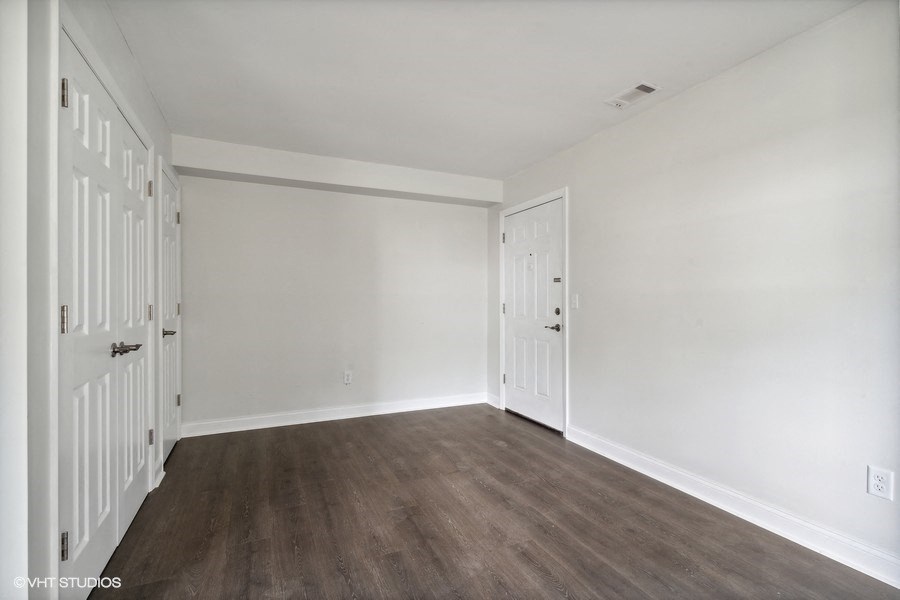 an empty bedroom with white walls and wood floors