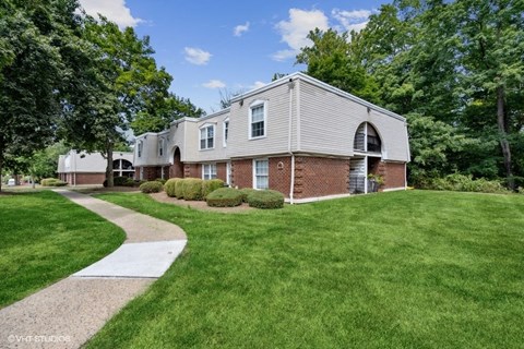 a white and brick house with a walkway in front of it