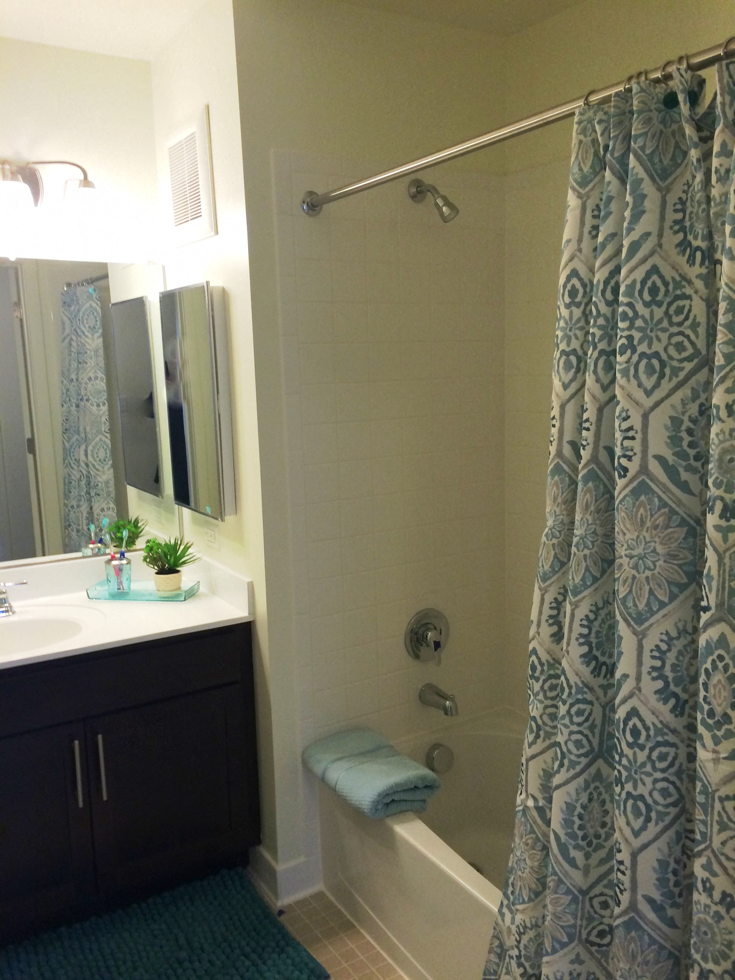 a bathroom with a shower and a sink and a shower curtain