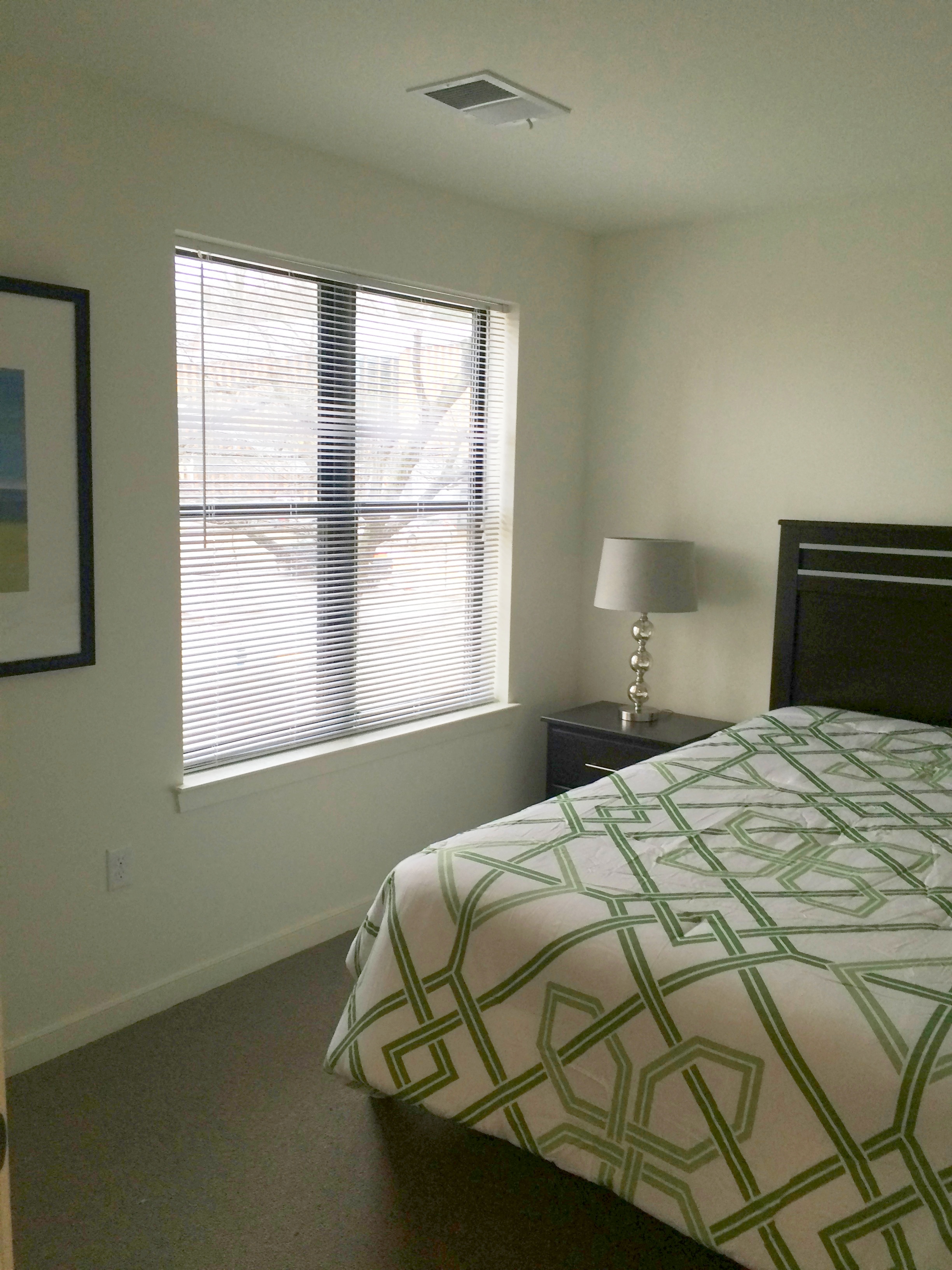 a bedroom with a bed and a window