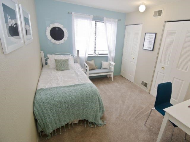 a small bedroom with a bed and a window