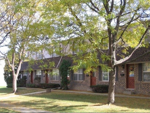 a brick house with trees in front of it
