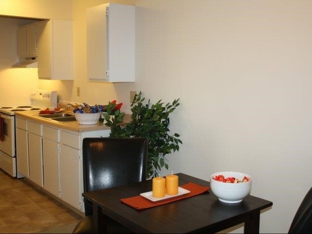 a kitchen with a table and a bowl of orange juice