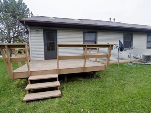 a house with a deck and stairs in a yard