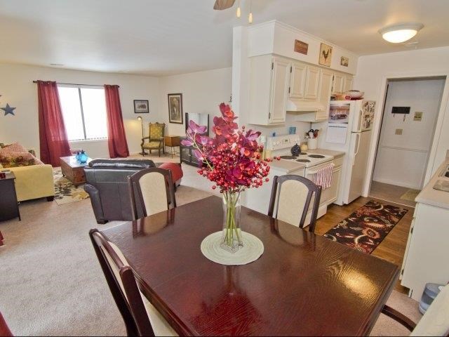 a dining room table with a vase of flowers on it
