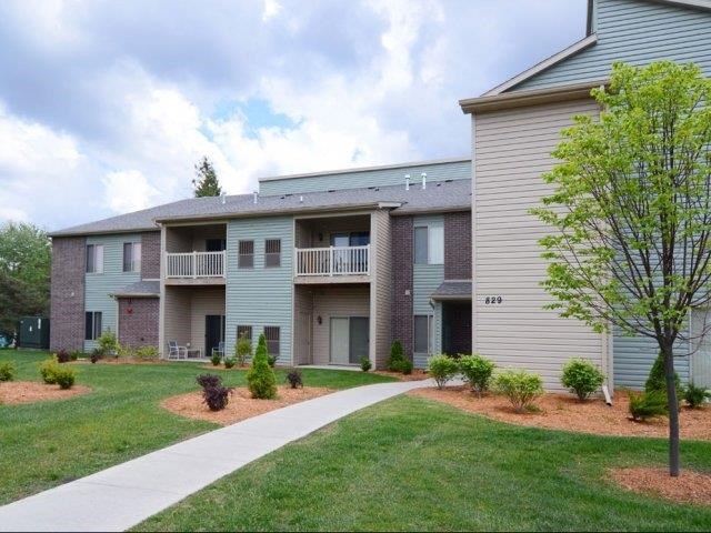 an apartment building with a sidewalk in front of it