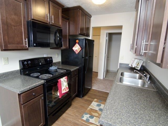 a kitchen with a stove refrigerator and a sink