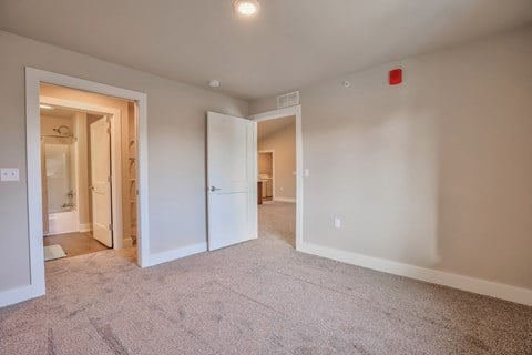 a living room with carpet and a door to a bathroom