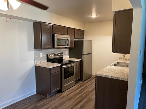 a kitchen with stainless steel appliances and marble counter tops