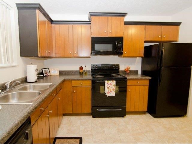 a kitchen with black appliances and wooden cabinets