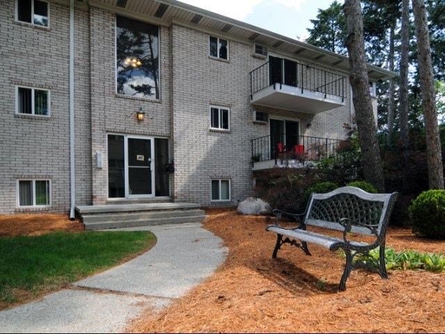 a bench sitting in front of a brick house