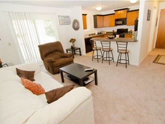 a living room with a couch and a kitchen