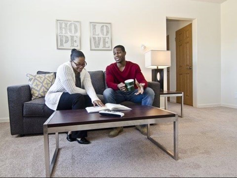 two people sitting on a couch in a living room