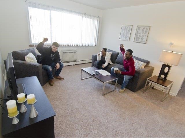 three men sitting on couches in a living room