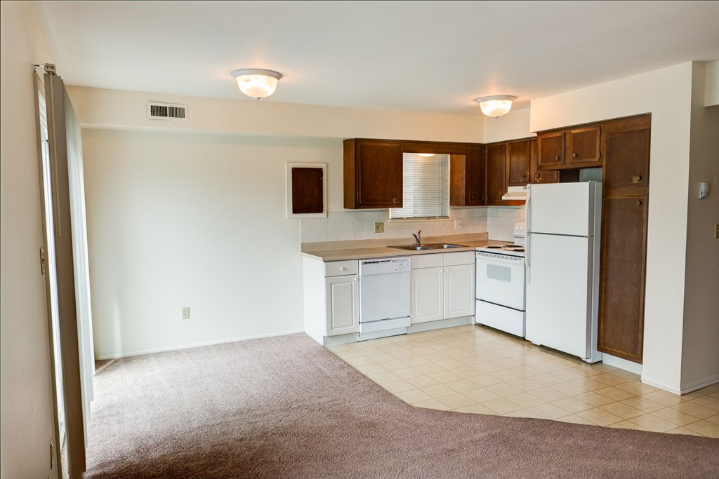 an Spacious Kitchen in East Lansing Apartments near Michigan State University | Courtyard Flatletskitchen with white appliances and wooden cabinets