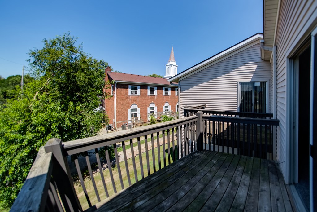 the deck of a house with a church in the background