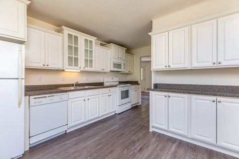 a kitchen with white cabinets and a stove and a sink