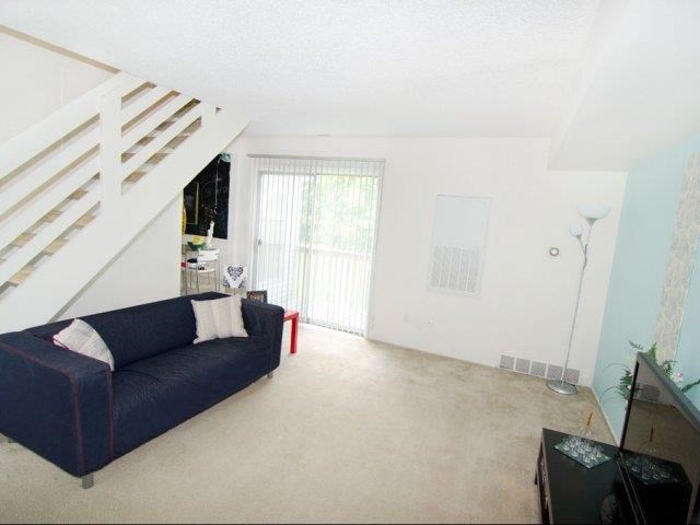 a living room with a blue couch and a staircase