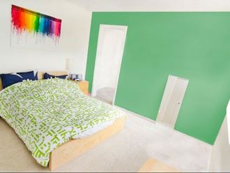 a bedroom with a green wall and a bed