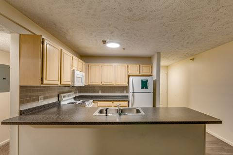 an empty kitchen with a counter top and a sink