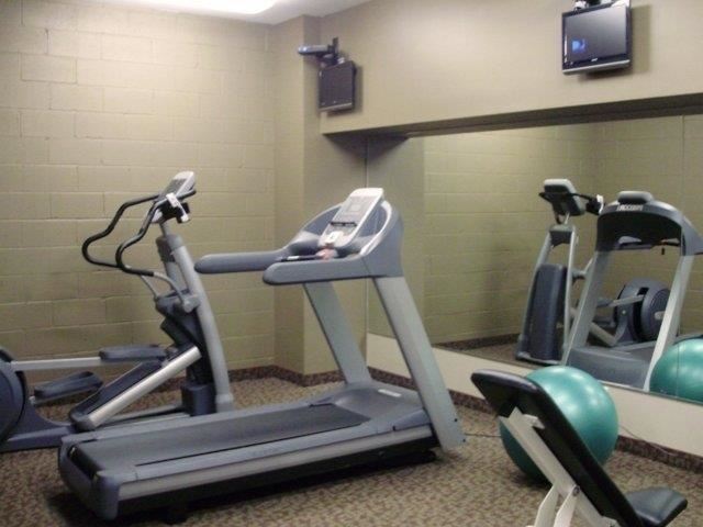 a gym with several machines and a tv on the wall