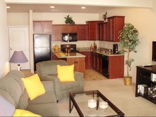 a living room and kitchen with a couch and a table