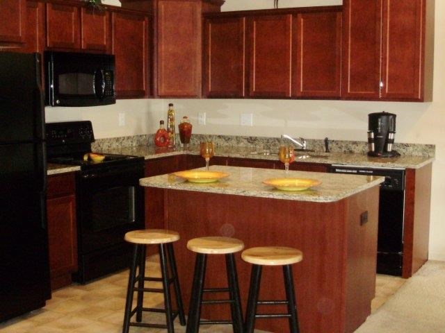 a kitchen with a counter and three bar stools