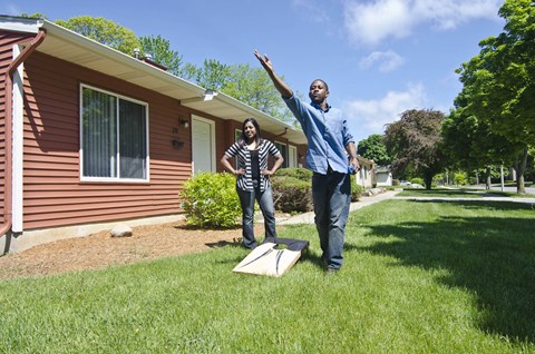 a man and woman standing in front of a house with a kite