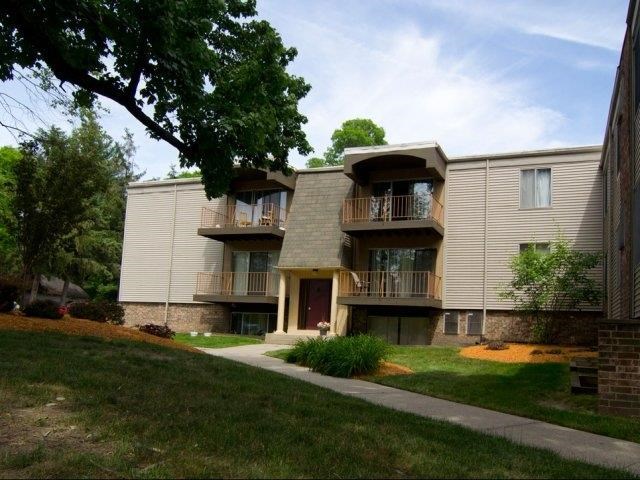 an apartment building with a sidewalk in the grass