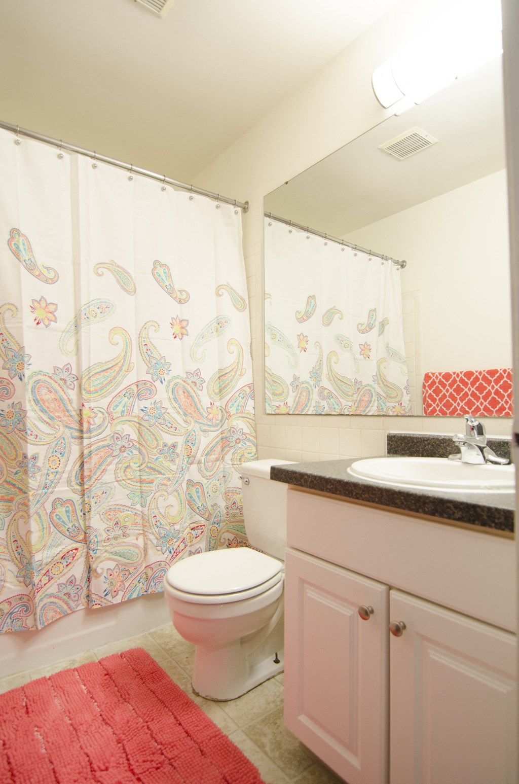 a bathroom with a toilet and a sink and a shower curtain