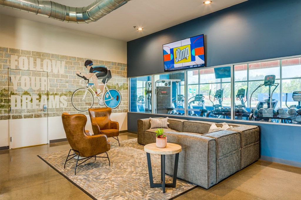 a living room with a couch and two chairs and a wall mural of a bike