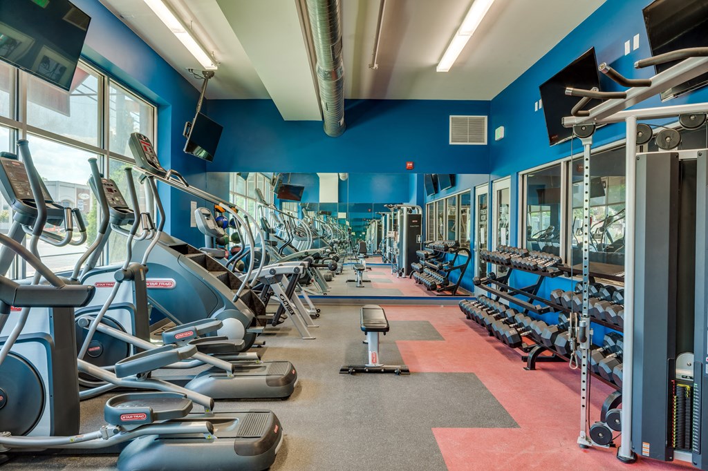 a fitness center with cardio equipment and weights in a gym