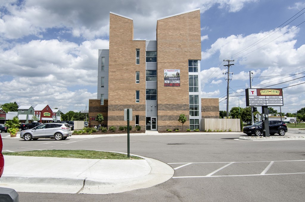 an empty parking lot in front of an apartment building
