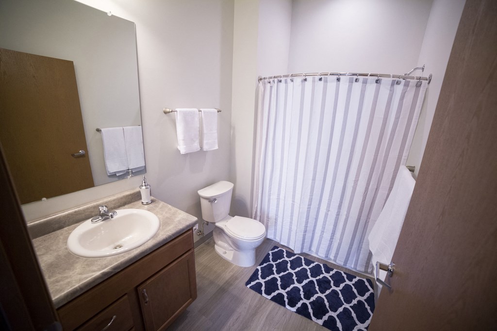 a bathroom with a sink toilet and shower in a residence hall room