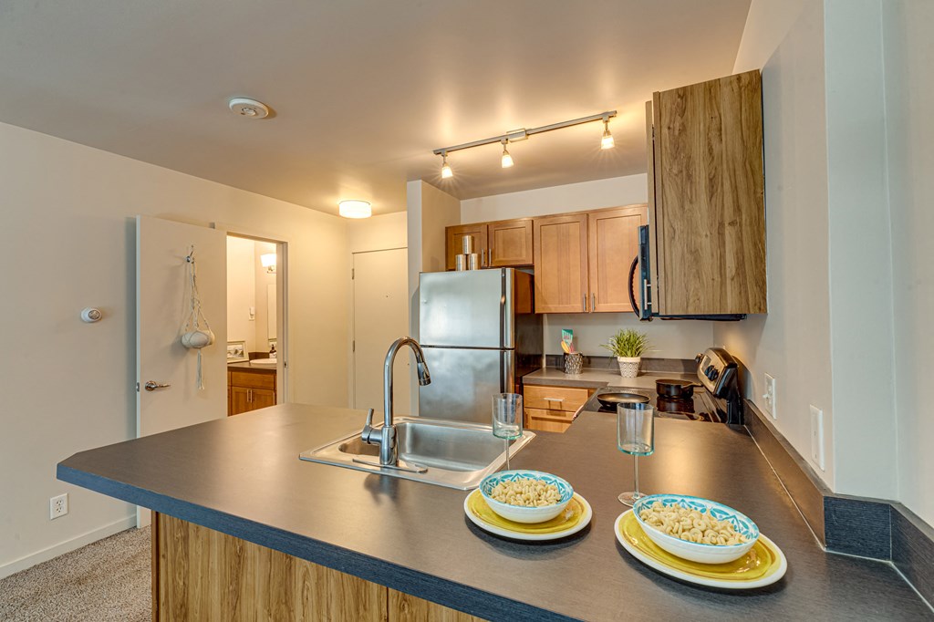 a kitchen with stainless steel appliances and a counter top with plates on it