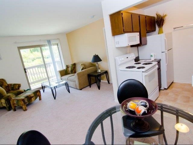 a living room with a kitchen and a table