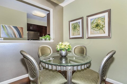 a dining room with a glass table and chairs