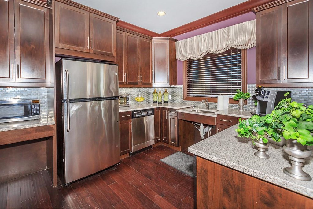 a kitchen with wooden cabinets and stainless steel appliances