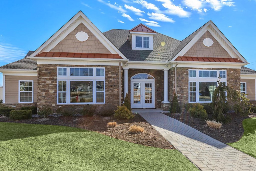 the front of a brick house with white windows